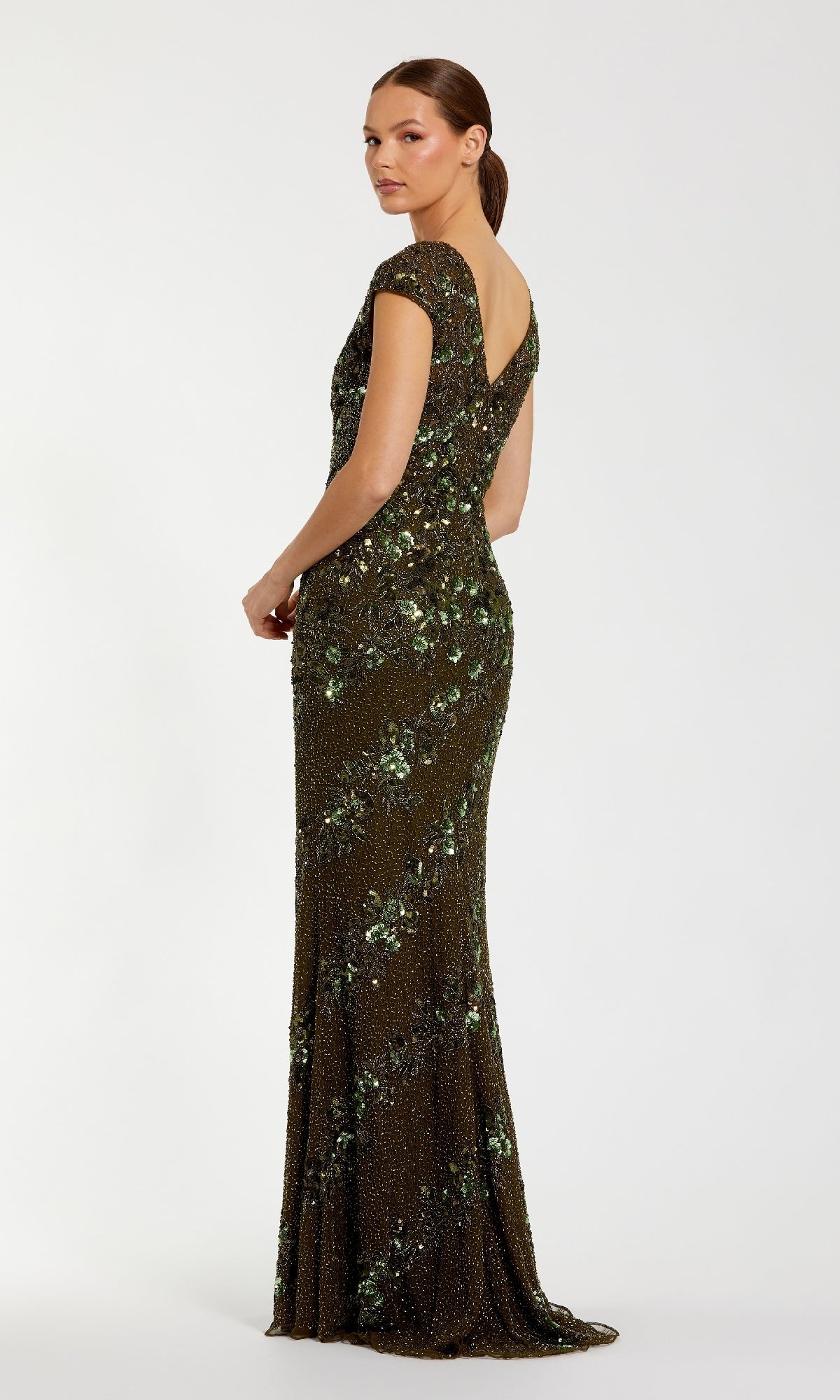 A woman models the Mac Duggal 5500 beaded long formal dress, featuring cap sleeves, a floor-length silhouette, sequins in a floral pattern, and a deep V-back, set against a plain white background.